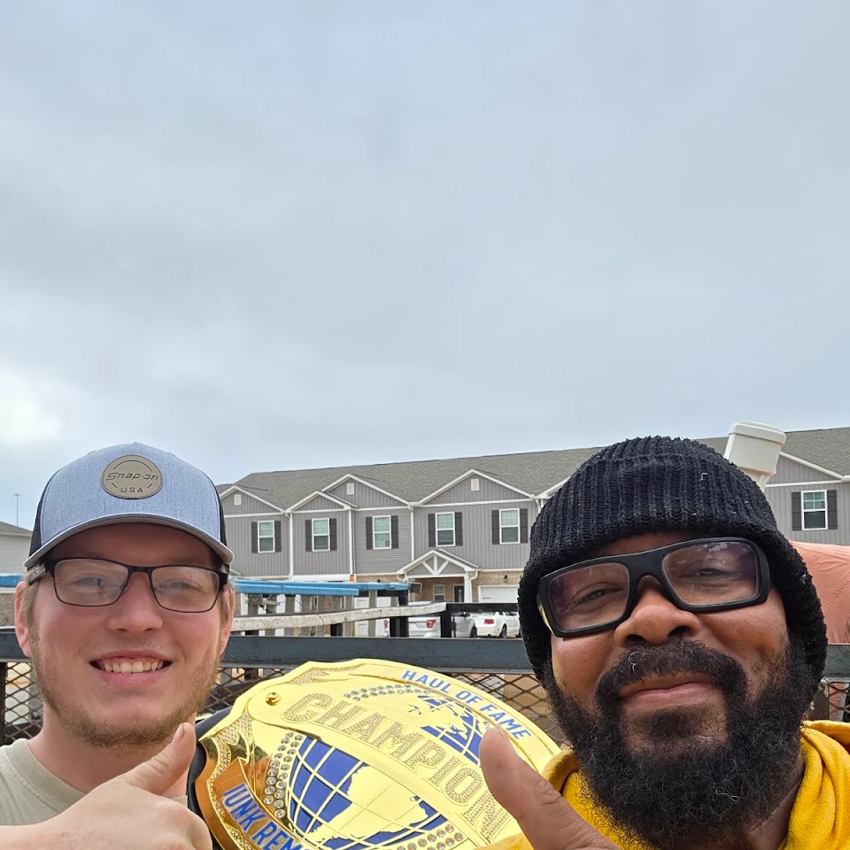 Haul Of Fame Junk Removal crew with the championship belt