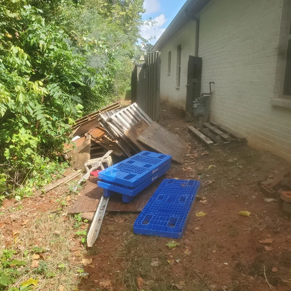 Debris along the side of a house before removal