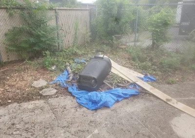 Yard debris and tarp before cleanup - Huntsville area junk removal