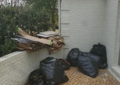 Trash bags beside a house for removal - Huntsville area junk removal