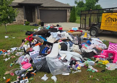 Large pile of household trash in a front yard - Huntsville area junk removal