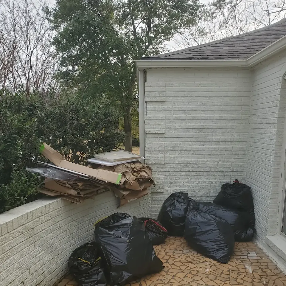 Trash bags and debris beside a house ready for pickup Trash bags and debris beside a house ready for pickup