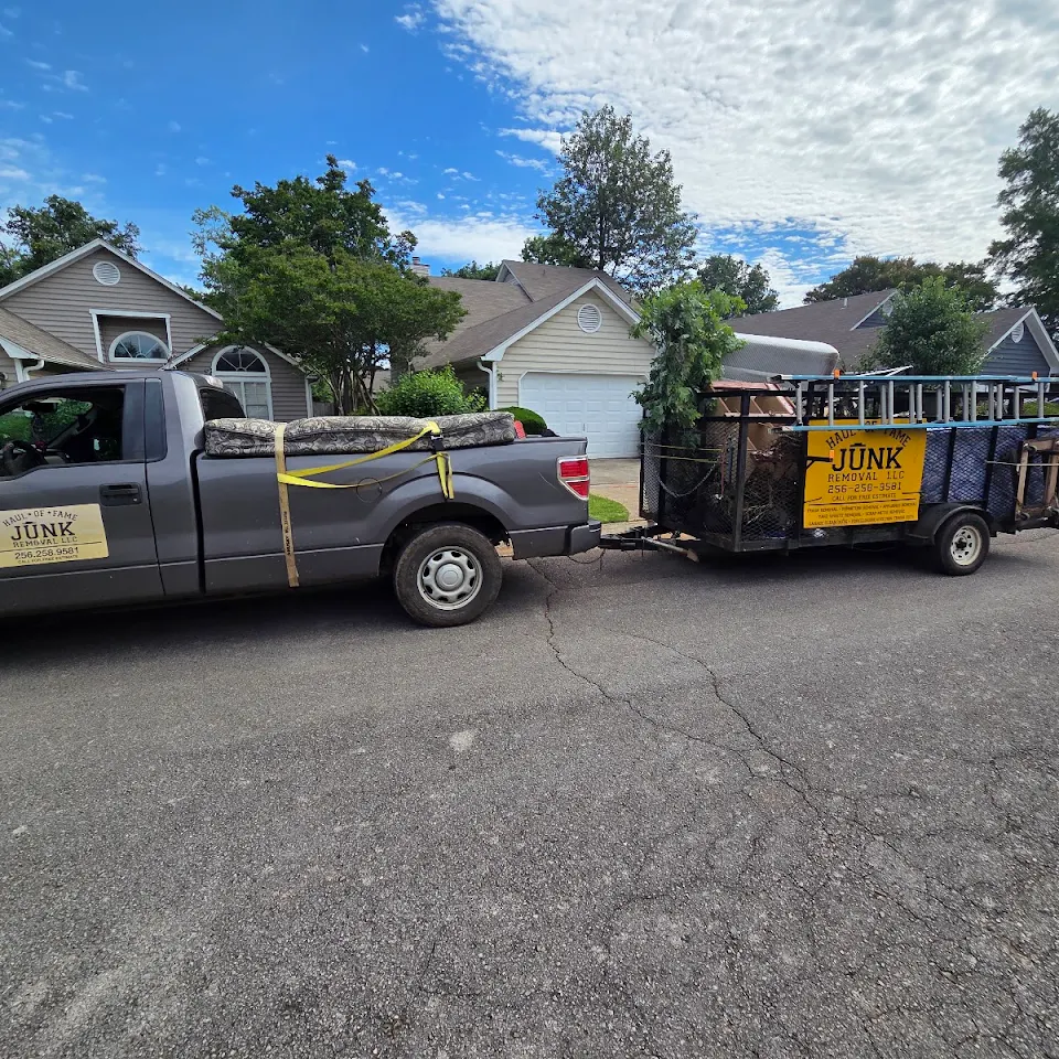 Haul Of Fame Junk Removal truck and trailer on a Huntsville area street Haul Of Fame Junk Removal truck and trailer on a Huntsville area street